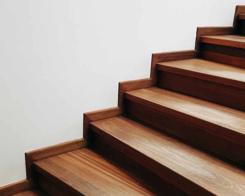 Timber stair treads rising against a plain wall