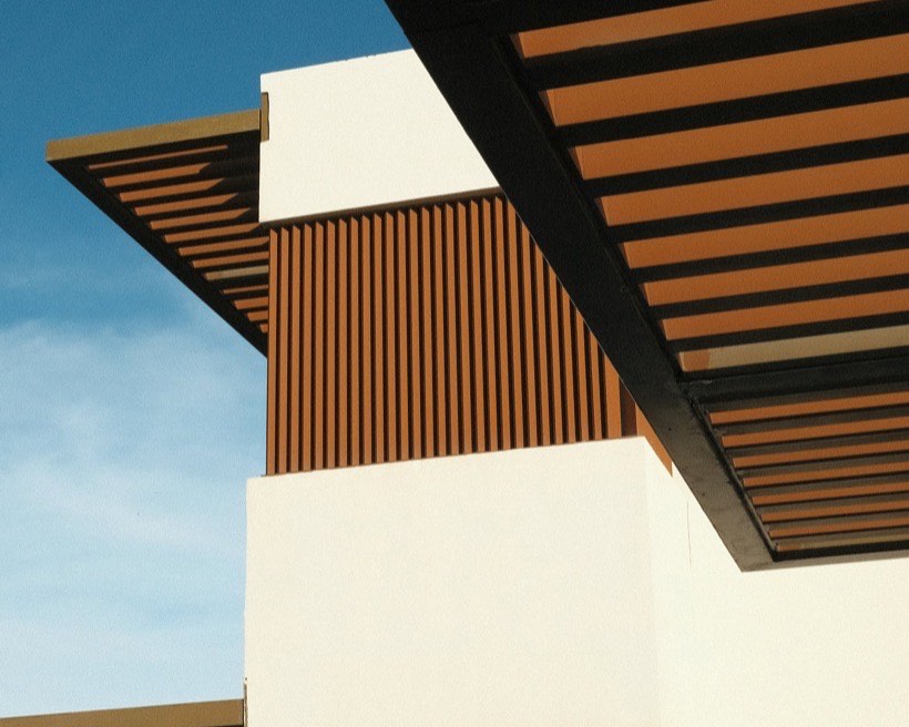 Timber batten screening and eaves against a clear blue sky